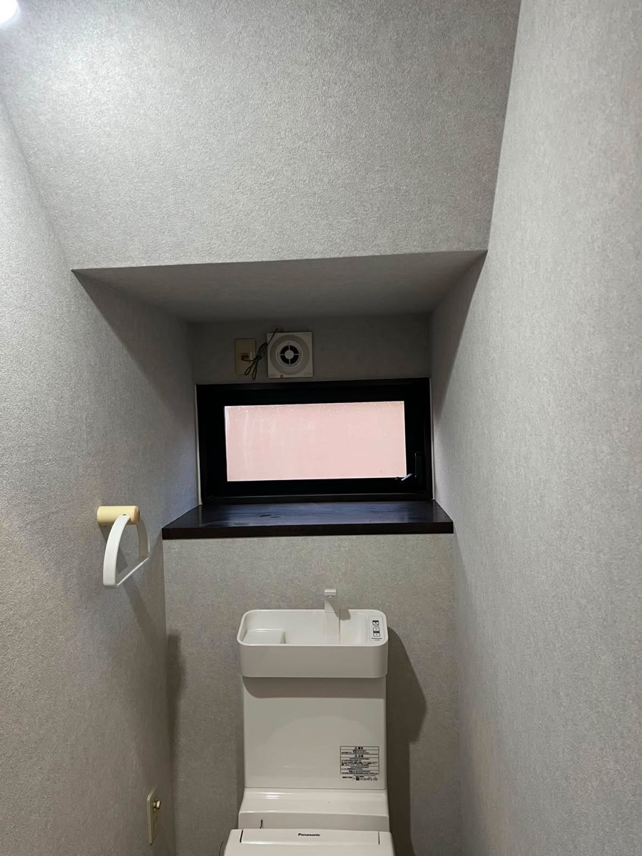 明るいグレーの壁紙のトイレ